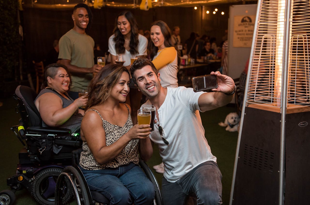 services-02 A cheerful group of friends taking a selfie with drinks at an indoor party.