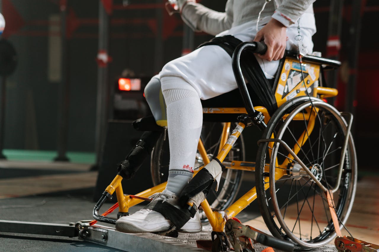 about-06 Focused athlete in wheelchair fencing gear, showcasing strength and determination.